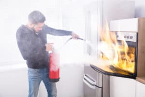 Man using fire extinguisher on stove